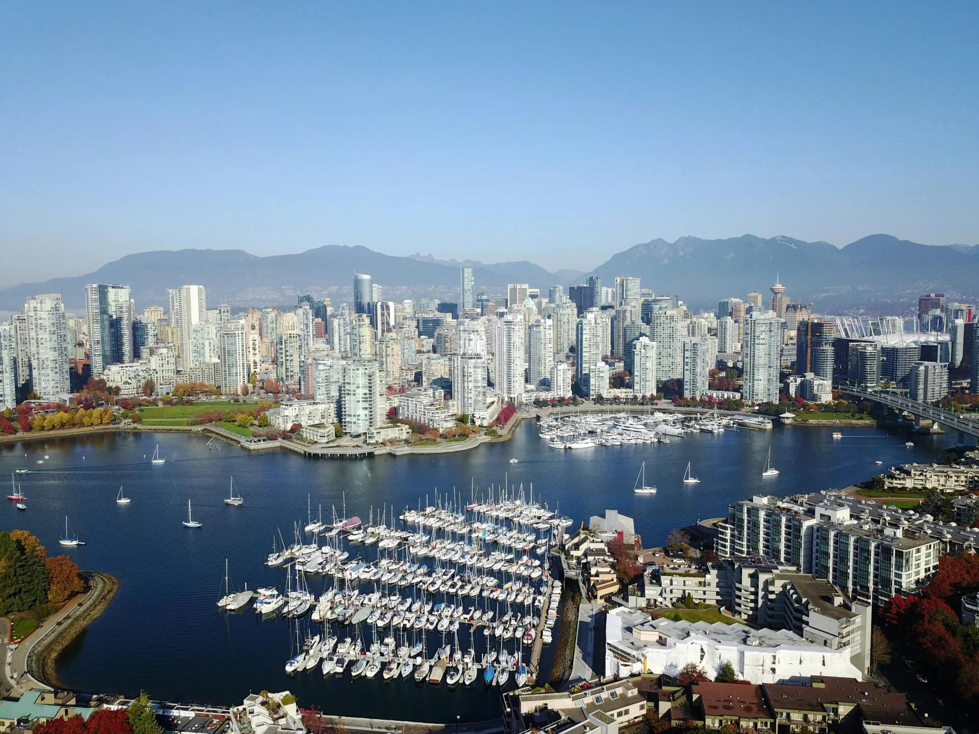 Aerial view of Vancouver's False Creek marina, skyline, and mountains